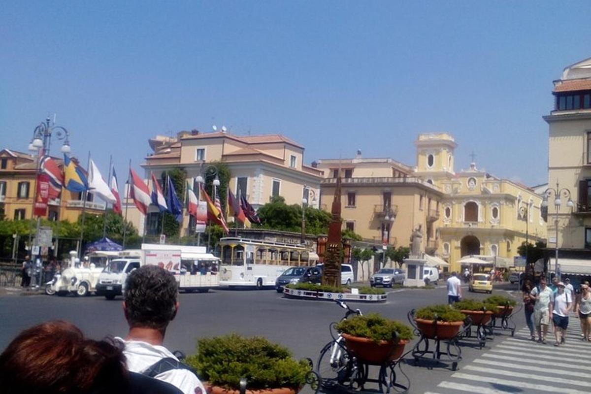 un gruppo di persone che guarda una strada con le bandiere