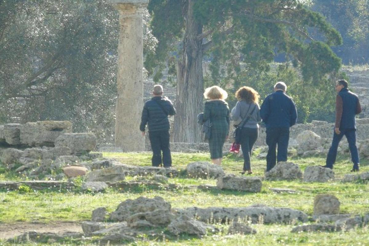 μια ομάδα ανθρώπων που περπατούν γύρω από ένα νεκροταφείο