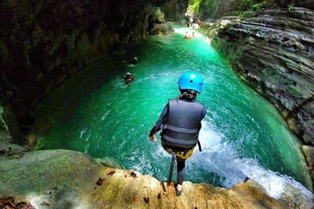 una persona in piedi su una roccia in un fiume