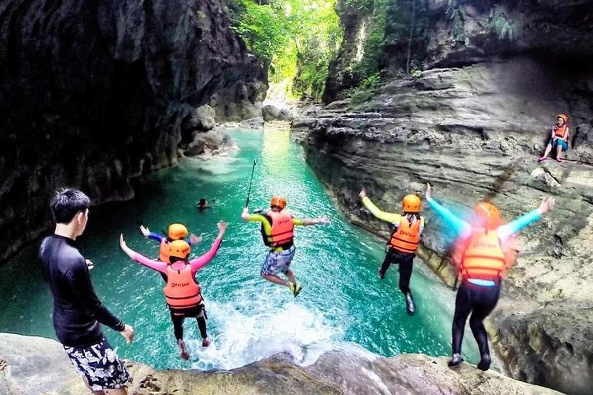 un gruppo di persone che saltano da una scogliera in un fiume