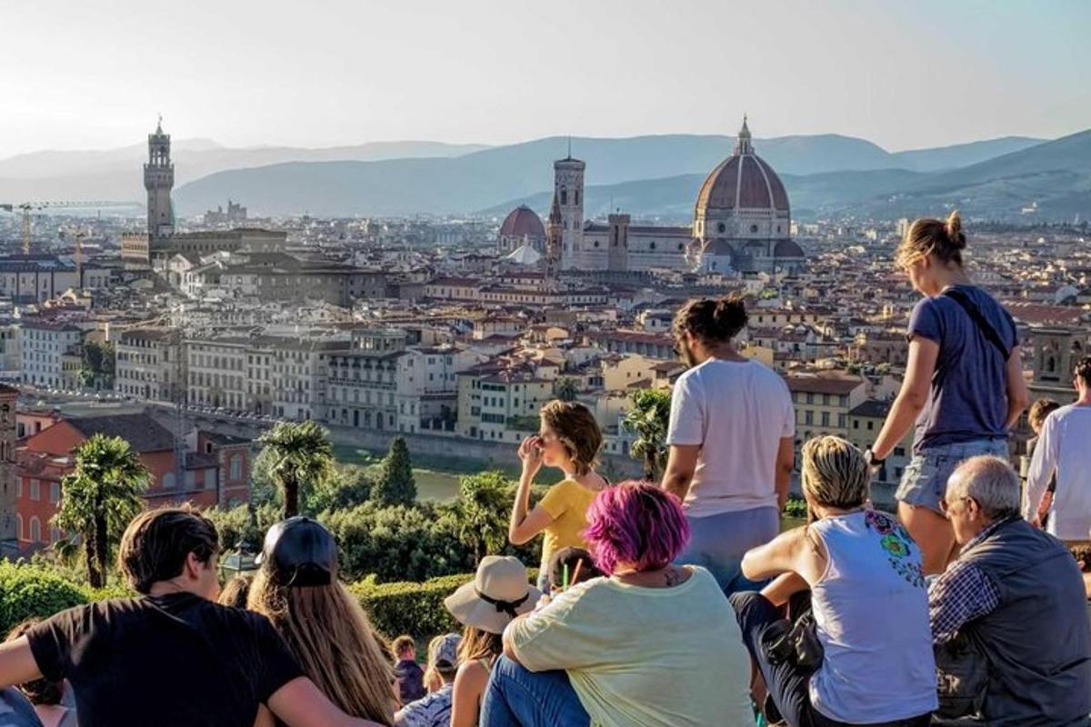 un gruppo di persone sedute su una collina che guardano una città