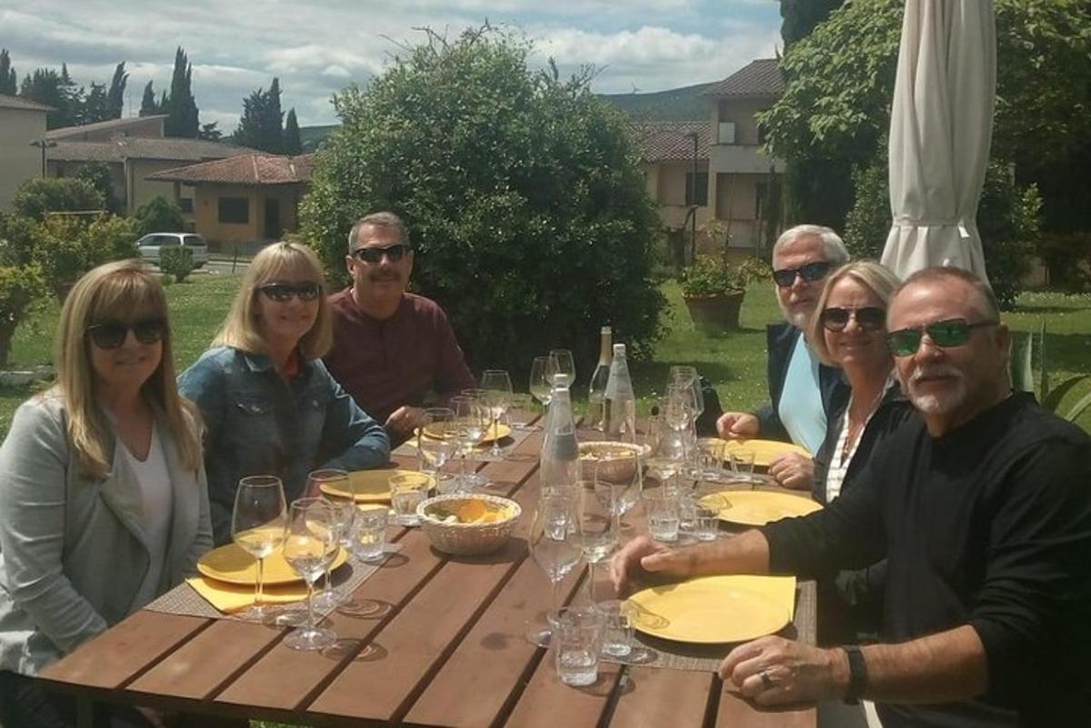 un grup de oameni așezați în jurul unei mese de lemn