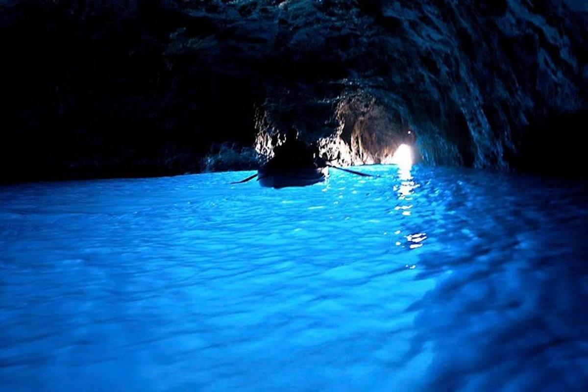 Una cueva con una luz en el agua por la noche.