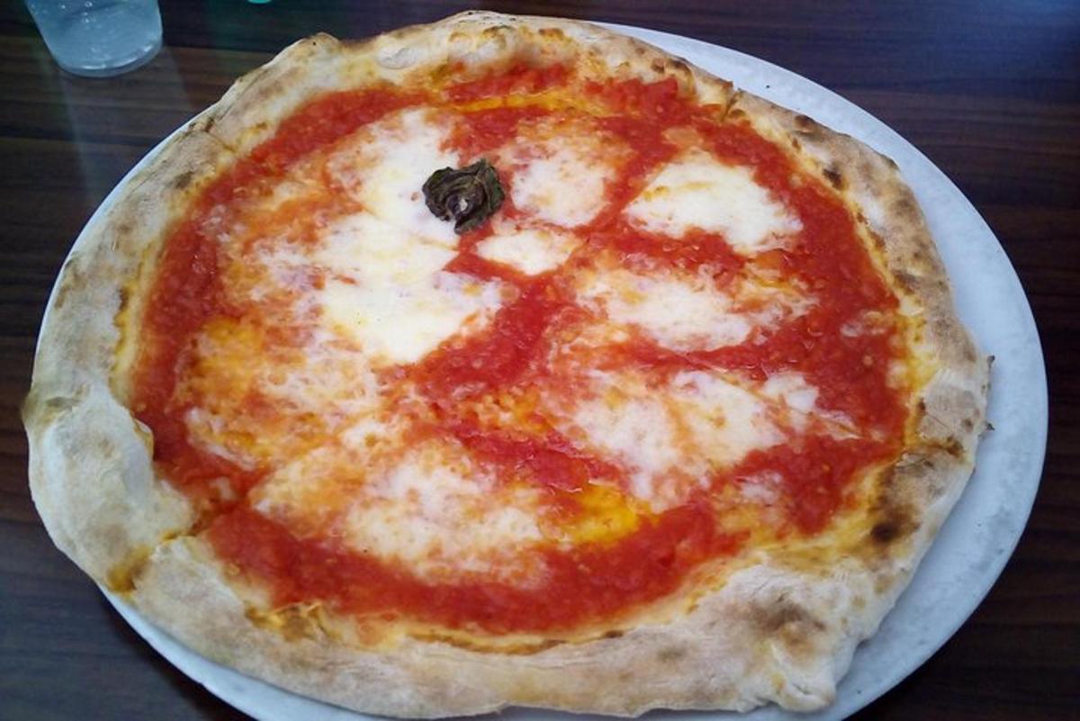 una pizza al formaggio appoggiata su un piatto su un tavolo