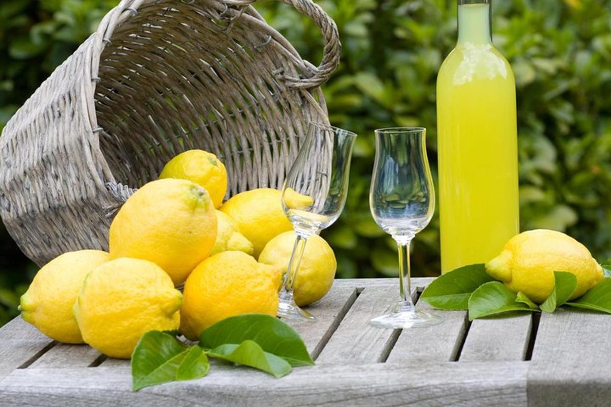 un mazzo di limoni appoggiato su un tavolo con bicchieri di vino