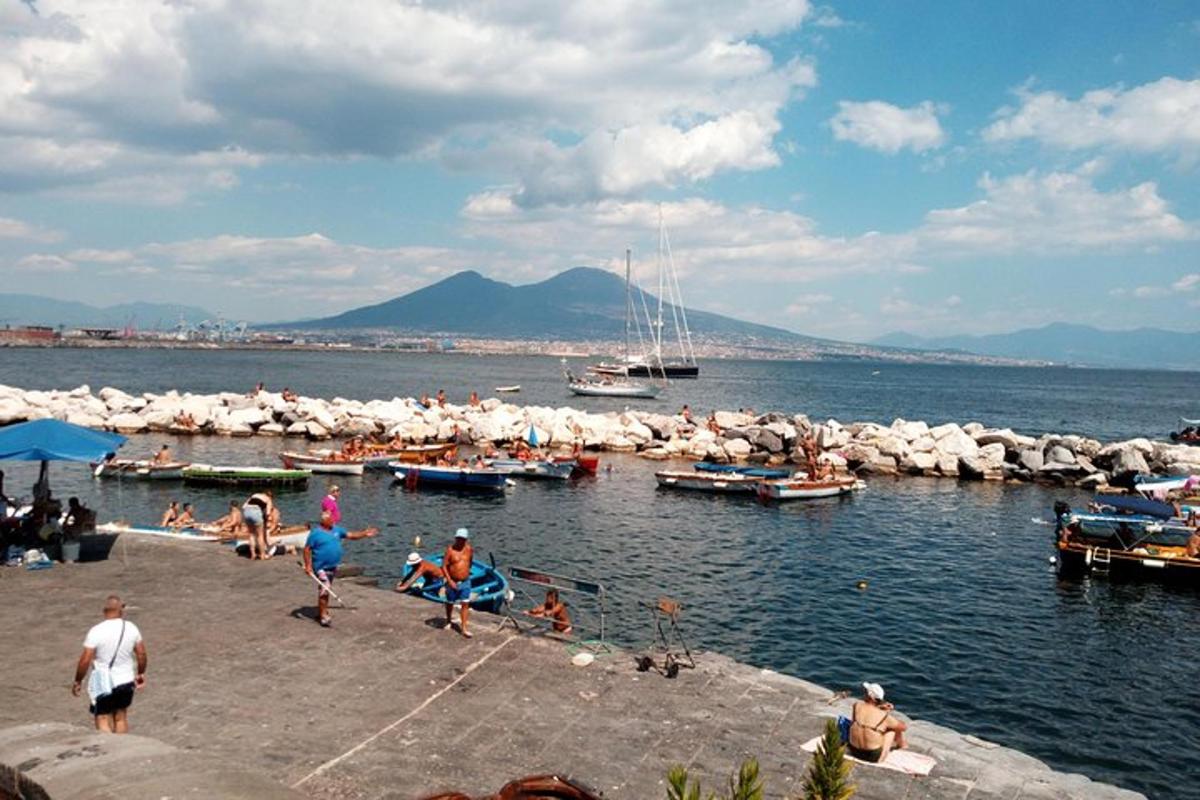 un gruppo di persone su una spiaggia con barche in acqua