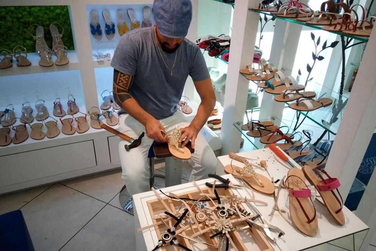 un uomo sta lavorando alle scarpe in un negozio di scarpe