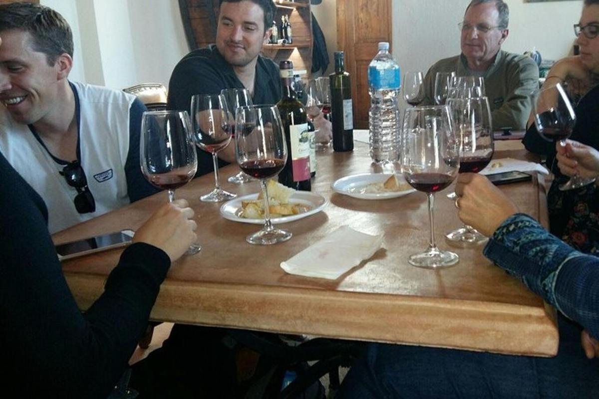 Un grupo de personas sentadas alrededor de una mesa con copas de vino.
