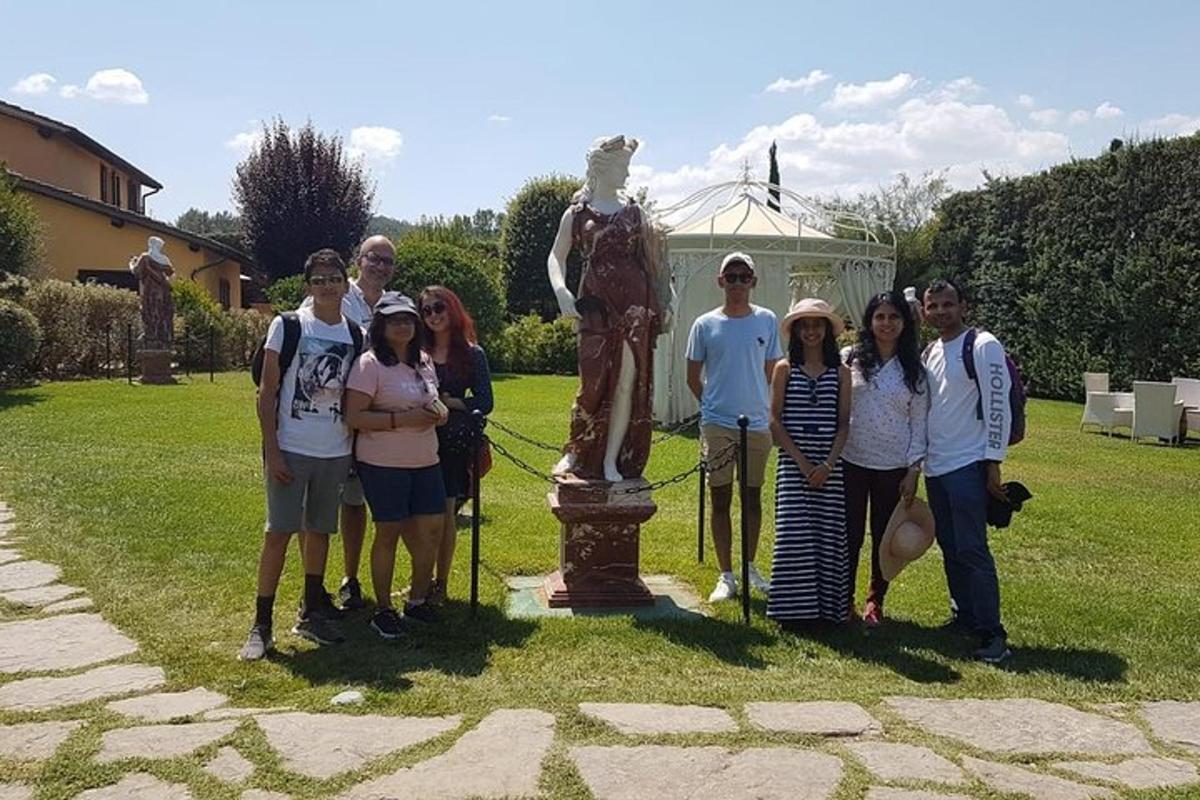 Un grupo de personas de pie frente a una estatua