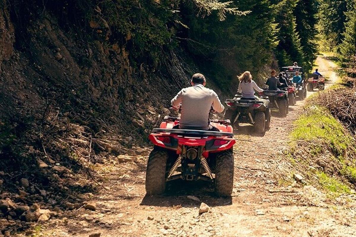 Un grupo de personas viajando en vehículos todo terreno por un camino de tierra.