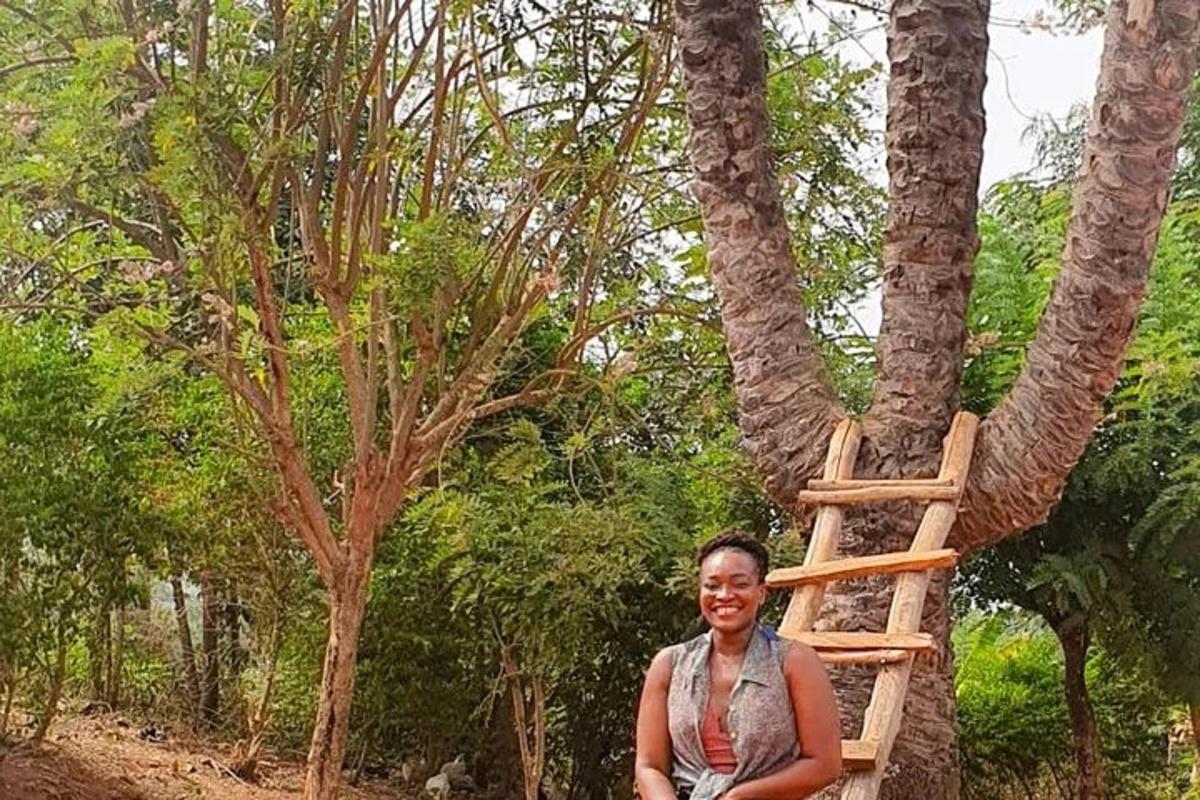 una dona dreta al costat d'un arbre amb una escala