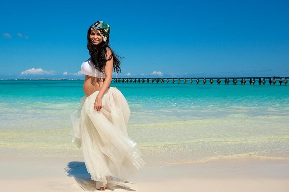 uma mulher grávida em um vestido de noiva na praia
