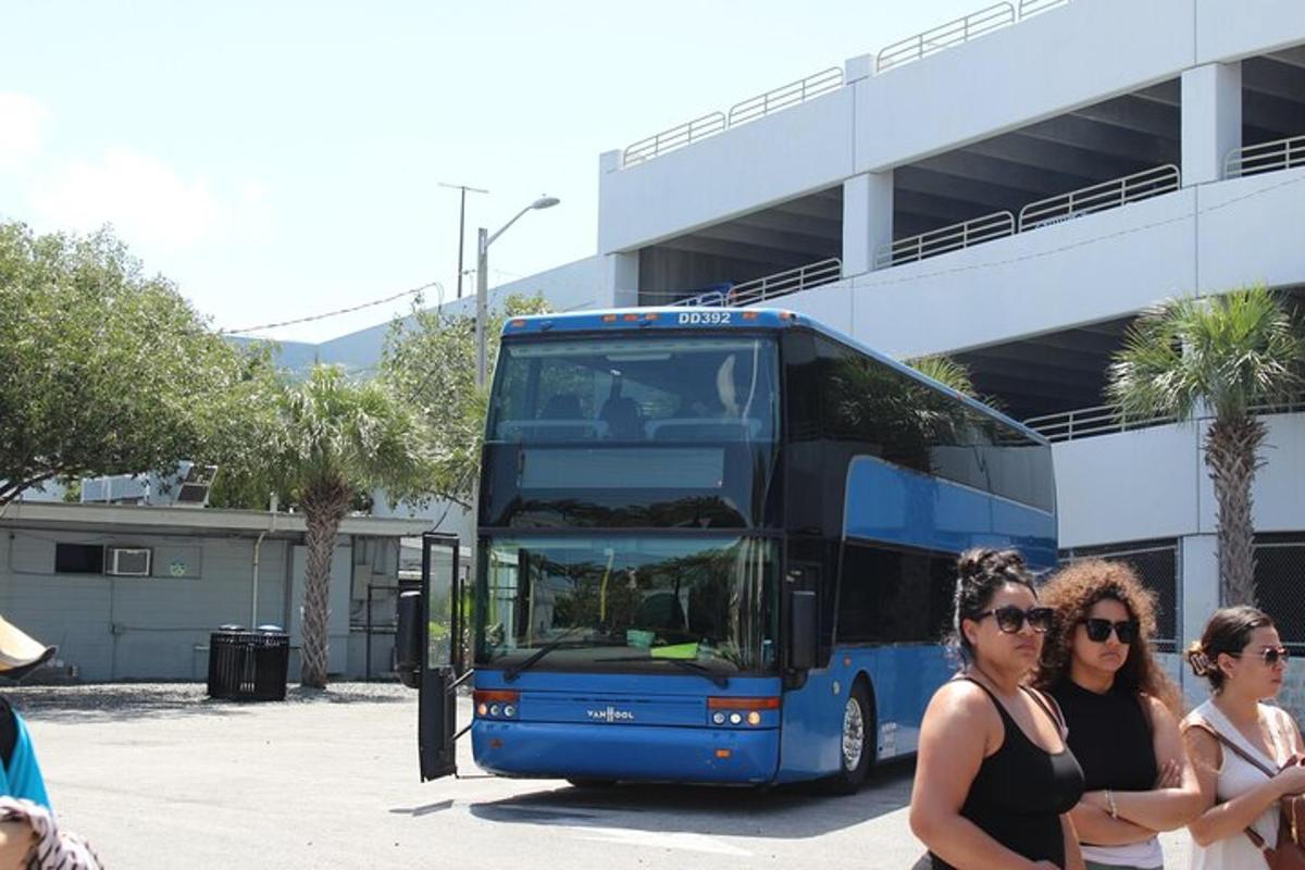 dvě ženy stojící před modrým dvoupatrovým autobusem