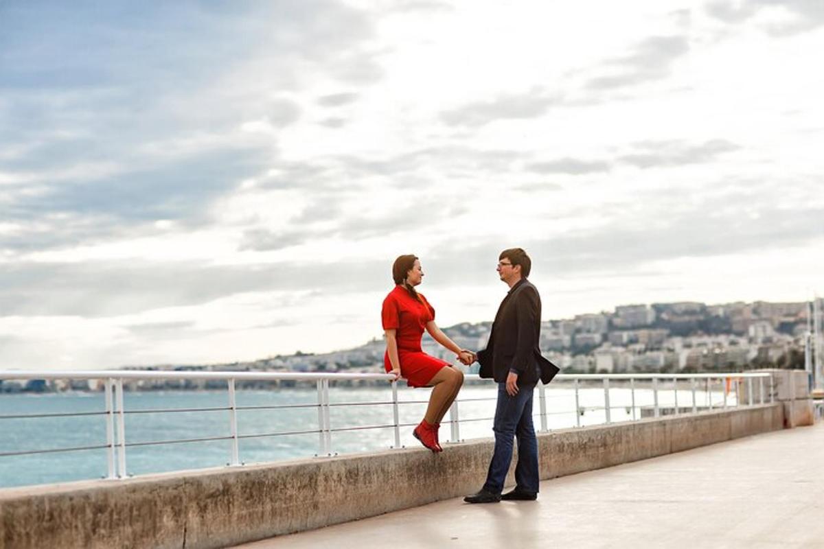 a woman in a red dress sitting on a wall with a man