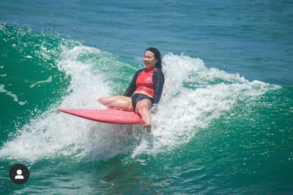 una donna che cavalca un'onda su una tavola da surf nell'oceano