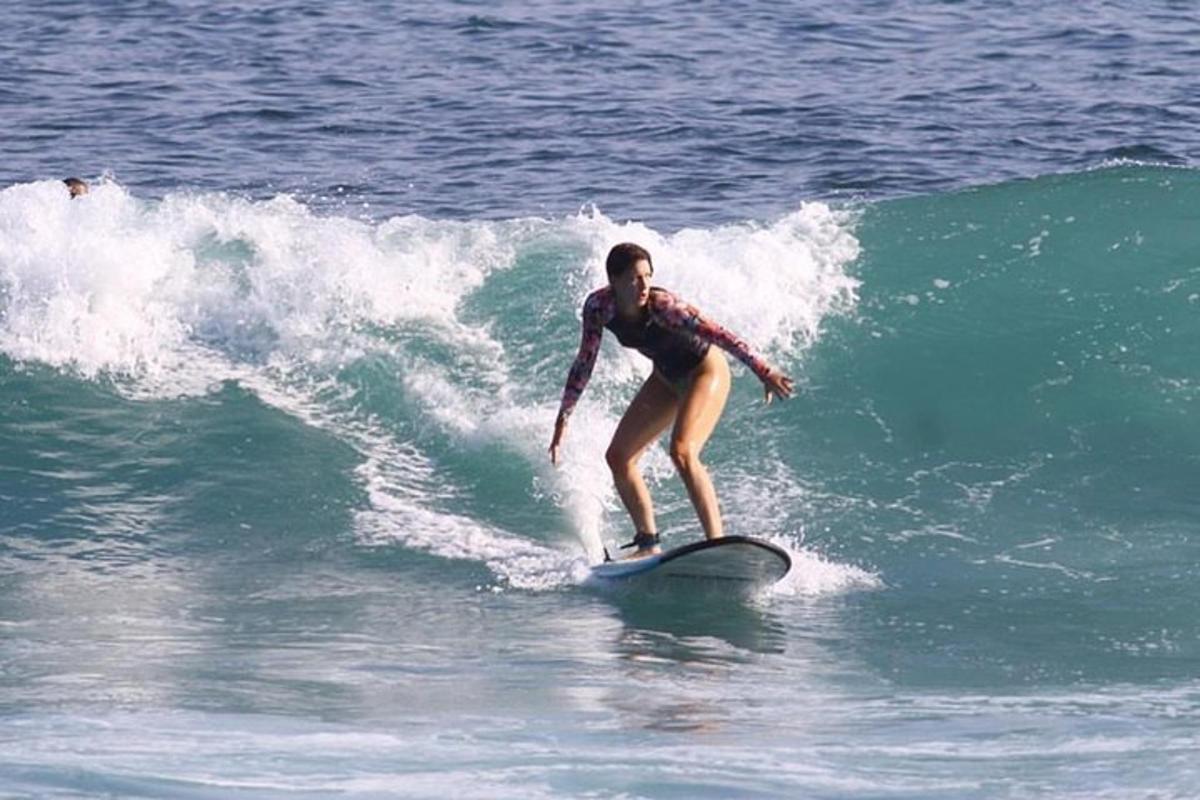 una donna che cavalca un'onda su una tavola da surf nell'oceano