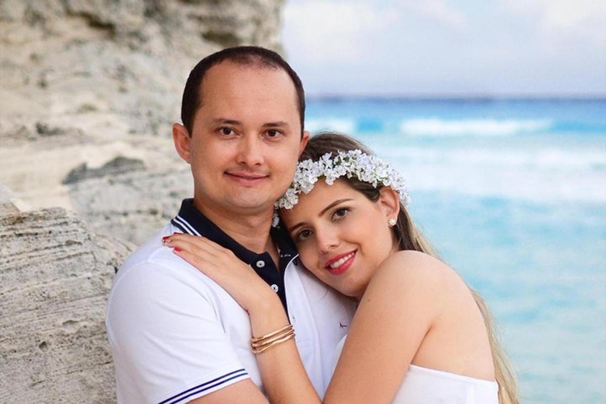 un homme et une femme posant pour une photo sur la plage