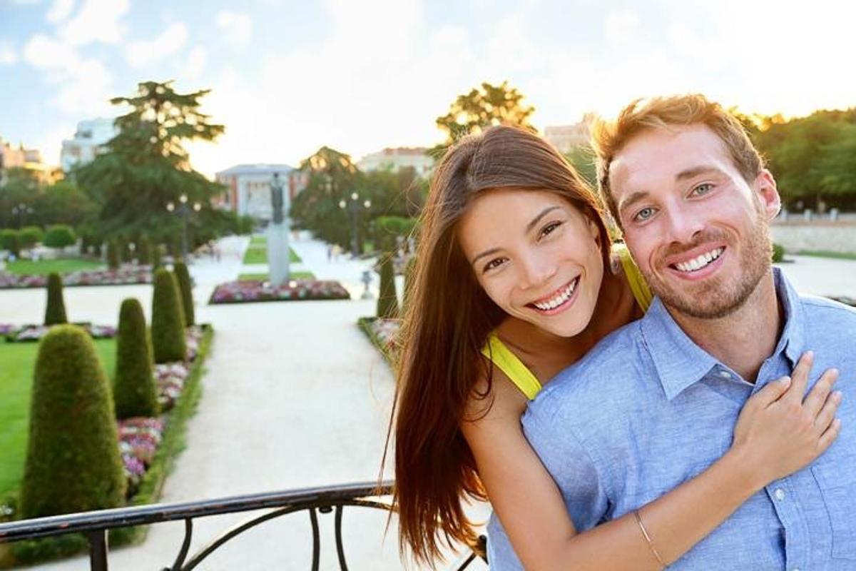 um homem e uma mulher posando para uma foto em um parque