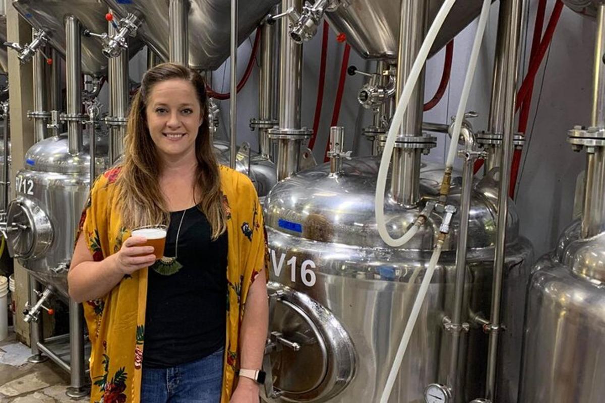 una dona dreta en una cerveseria sostenint una beguda