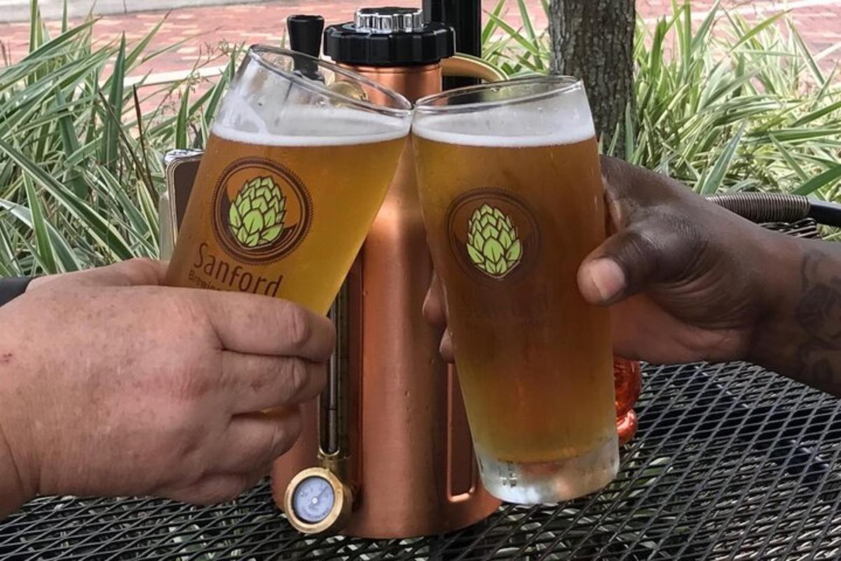 dues persones sostenint gots de cervesa i un termos