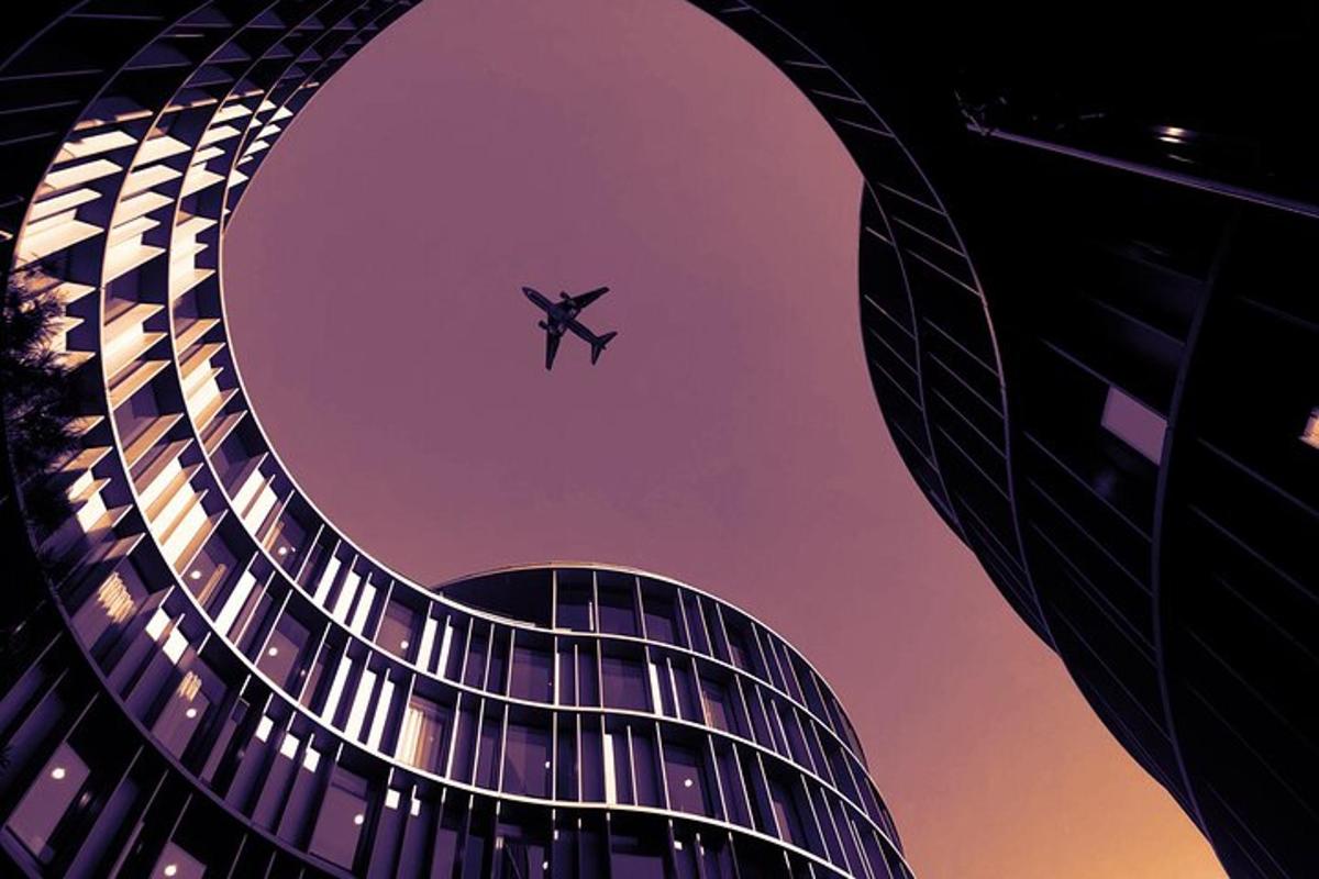pesawat terbang di langit di atas bangunan
