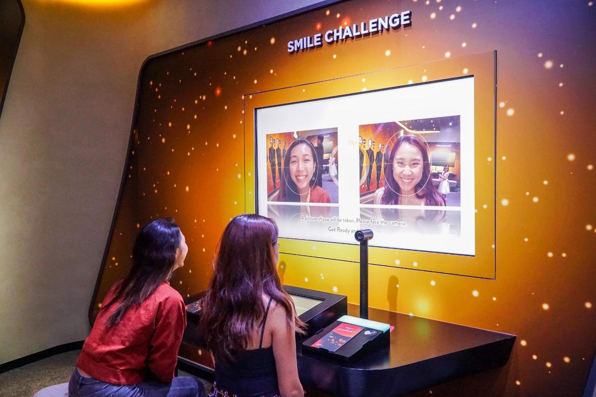 two women are watching a movie on a television screen
