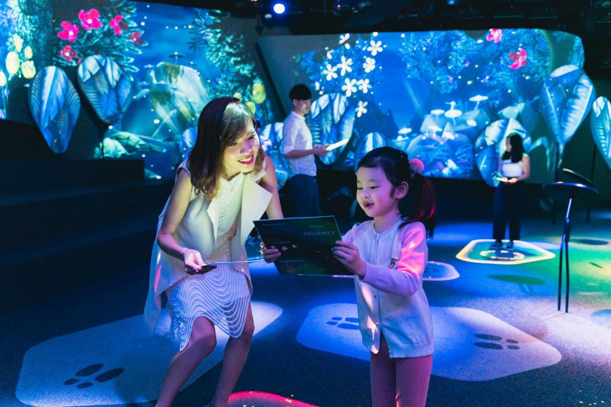a woman and a little girl in front of an aquarium