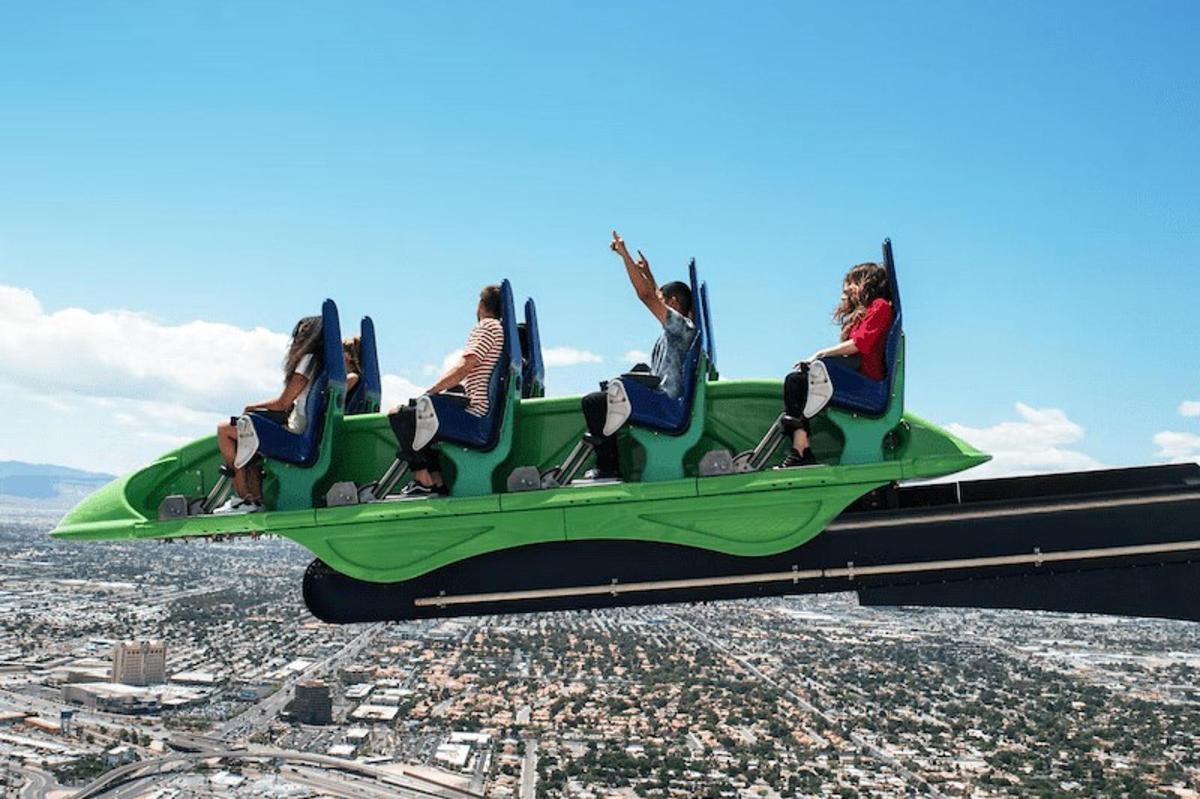 a group of people sitting on a green airplane in the sky