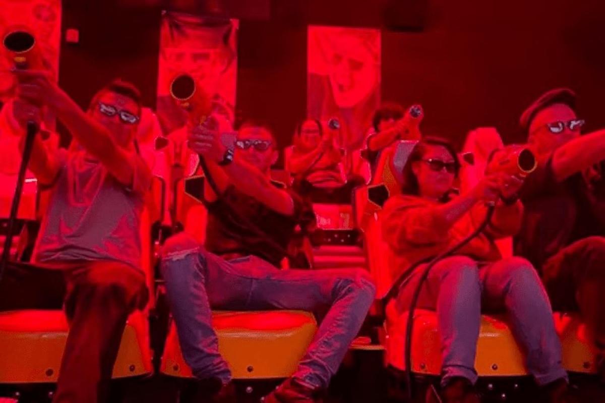 un gruppo di persone sedute in un teatro con luci rosse