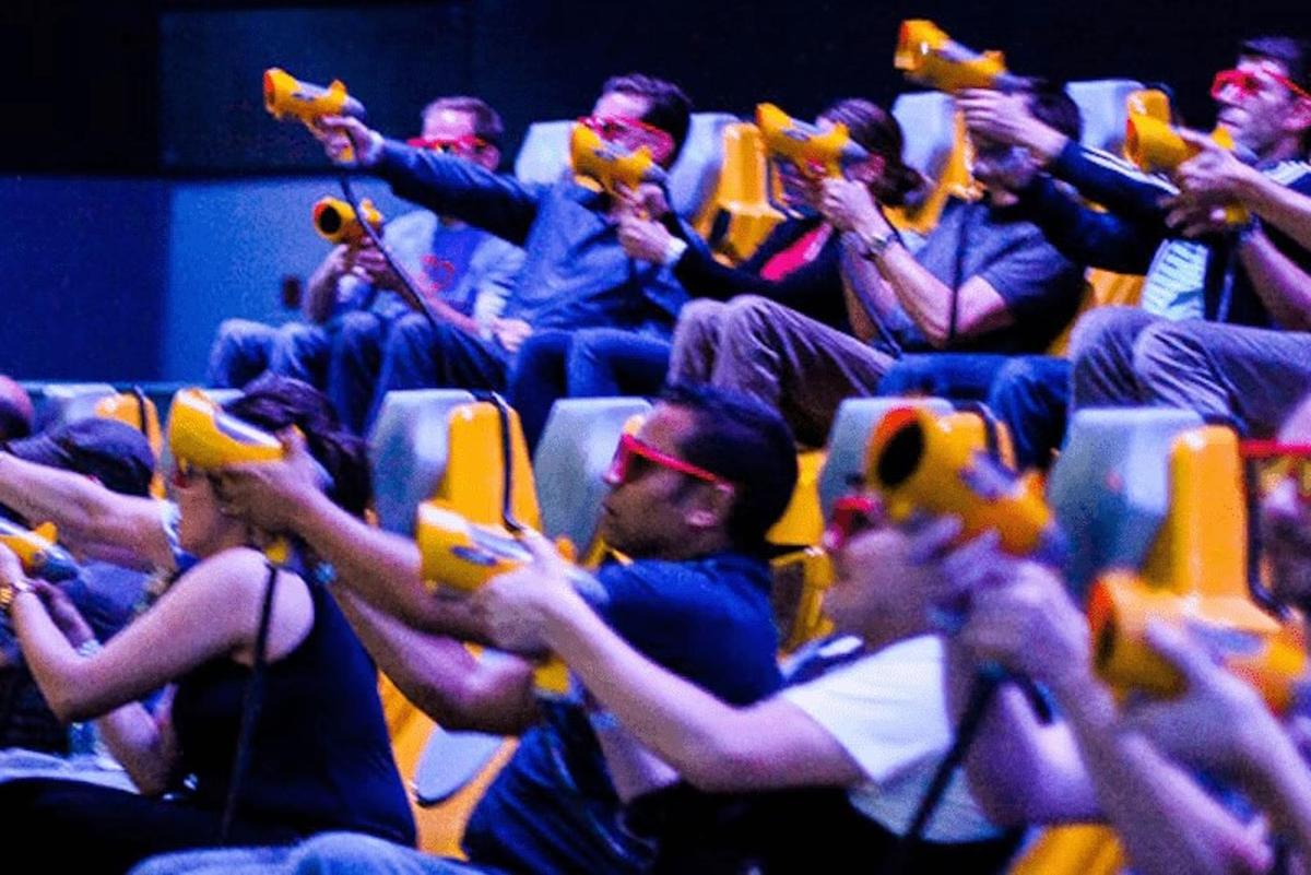 un gruppo di persone sedute tra il pubblico che tengono in mano i loro cellulari