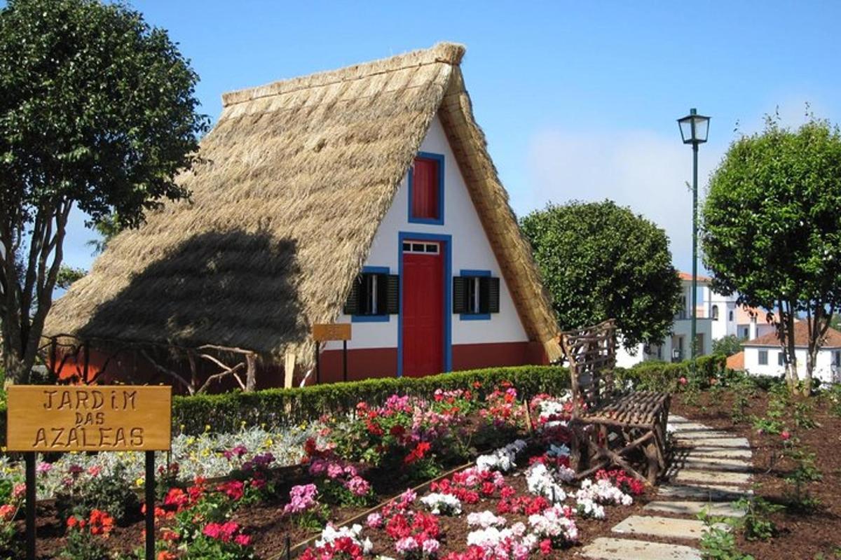 dům s doškovou střechou a zahradou s květinami