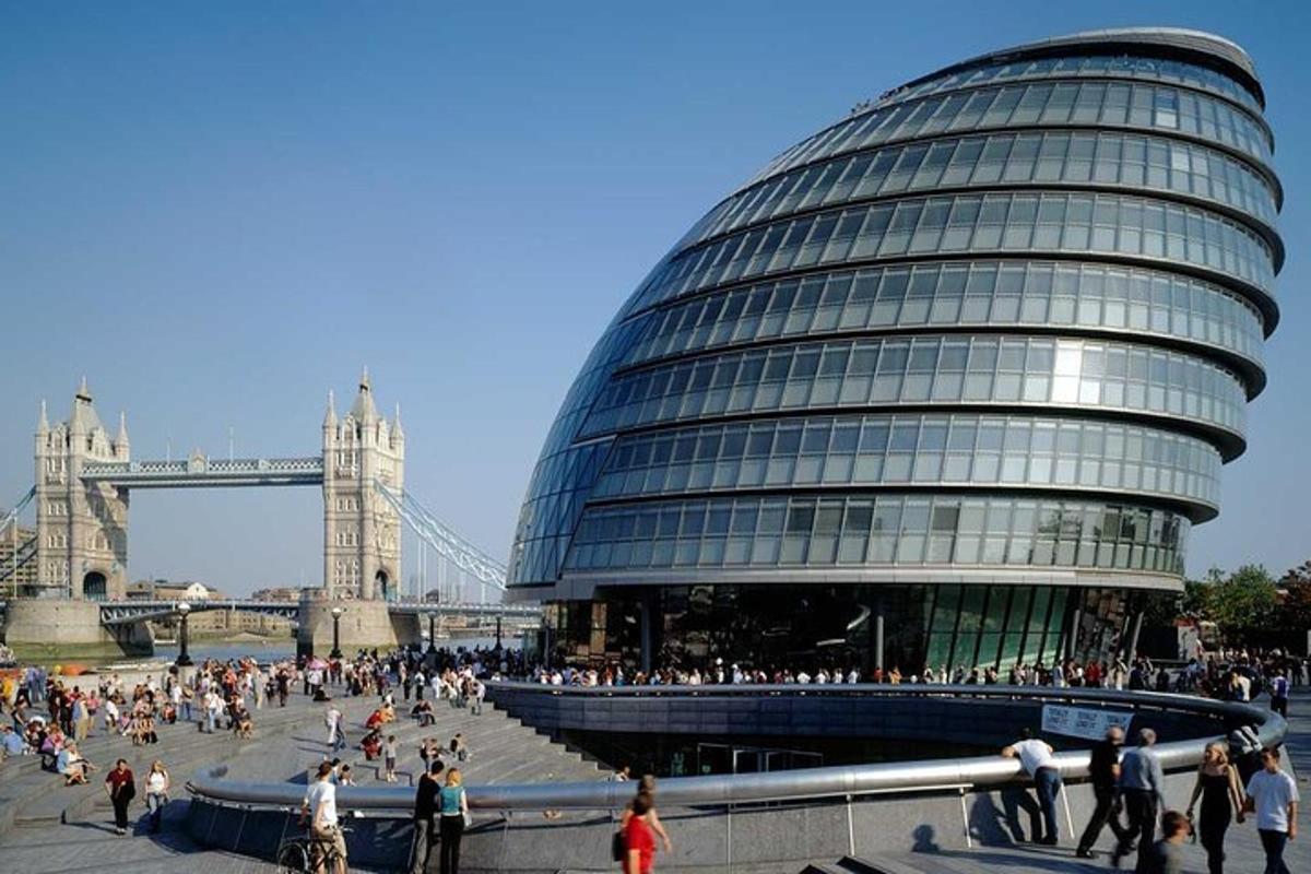 Dav lidí procházejících se kolem budovy s Tower Bridge