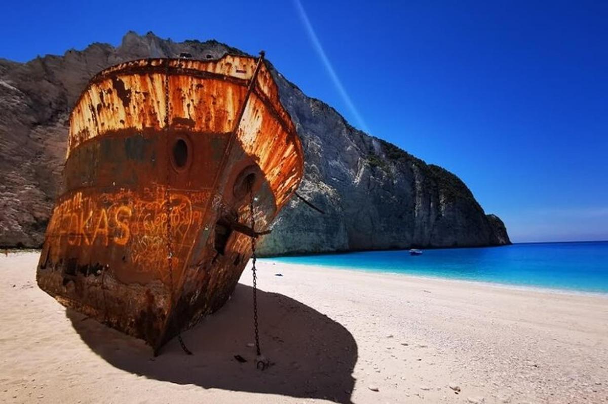 um velho barco parado em uma praia próxima ao oceano