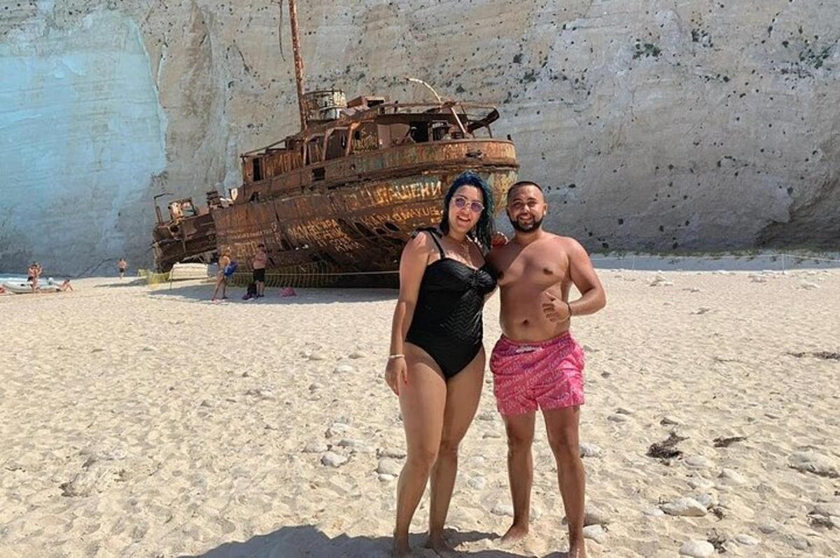 muž a žena stojící na pláži s lodí