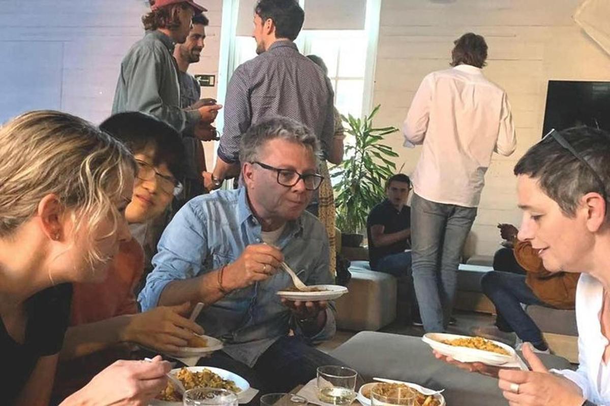 um grupo de pessoas sentadas ao redor de uma mesa comendo comida