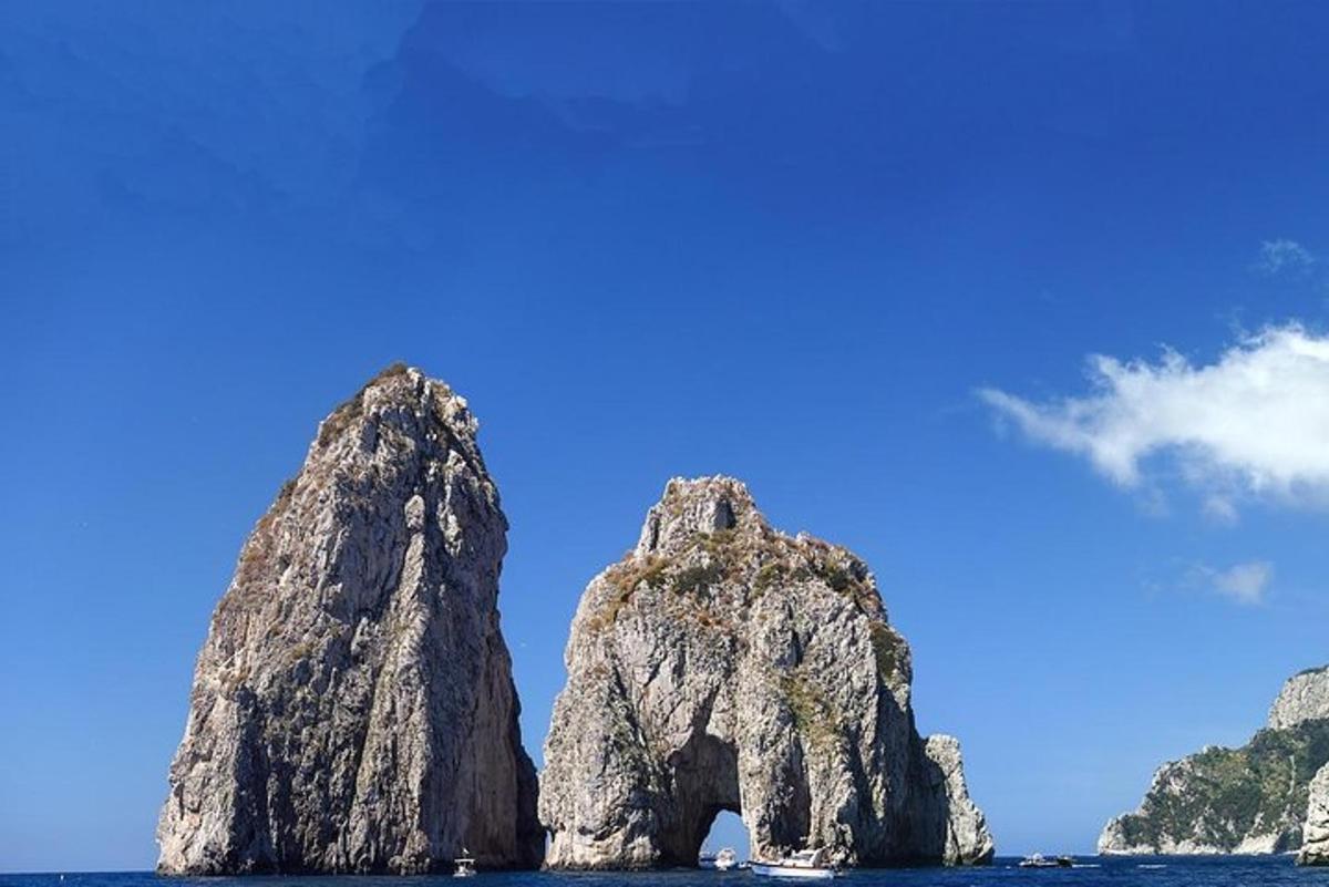 una formazione rocciosa nell'oceano con un cielo blu