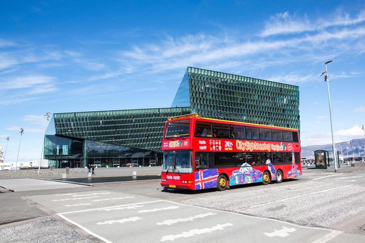 červený dvoupatrový autobus zaparkovaný před budovou
