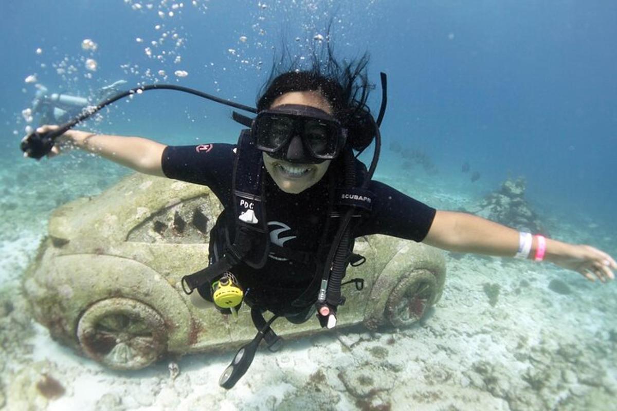 a person in a diver suit and goggles on a tank in the water