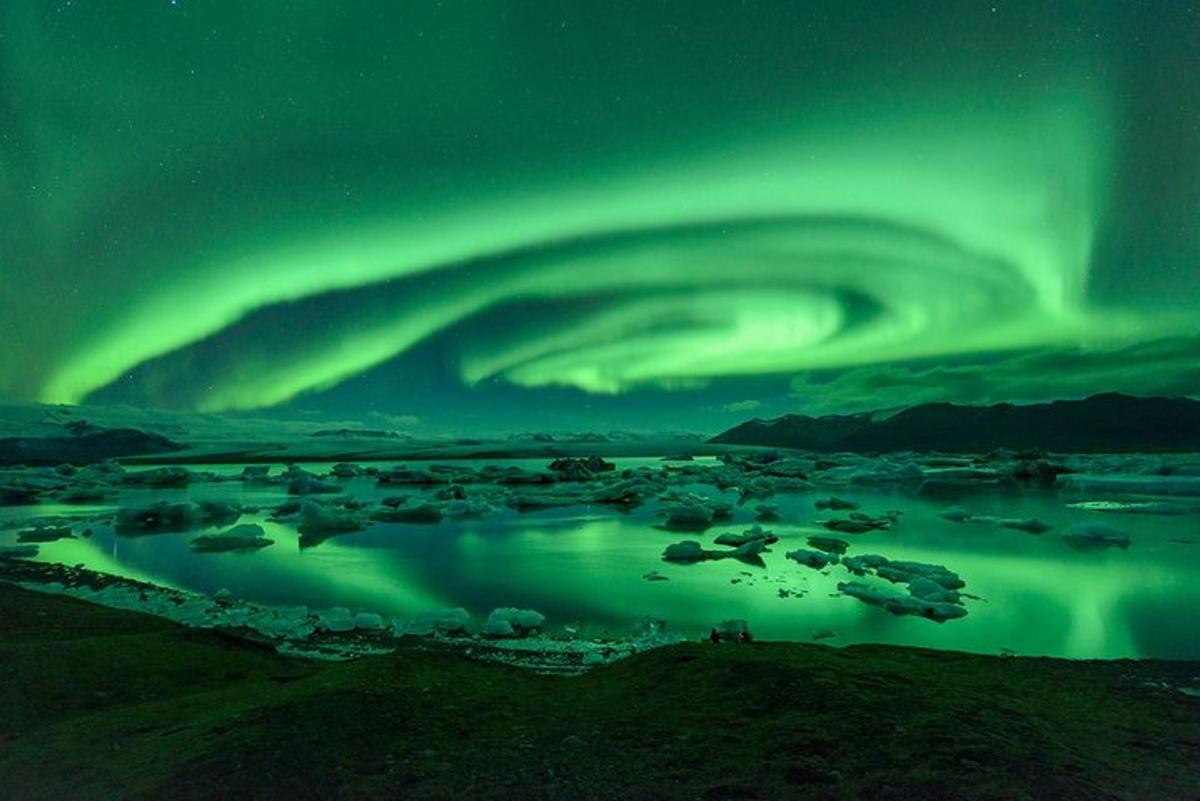 an aurora in the sky over a city with a river