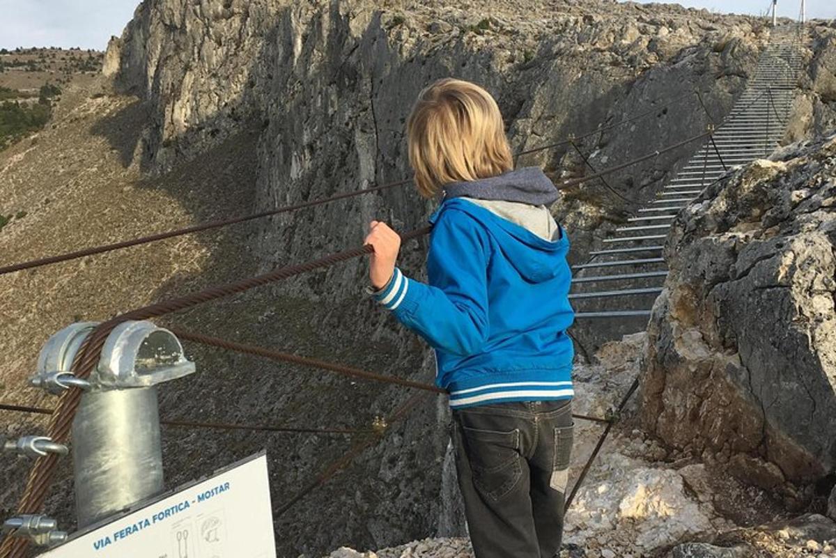 väike laps seisab trepi lähedal köiel