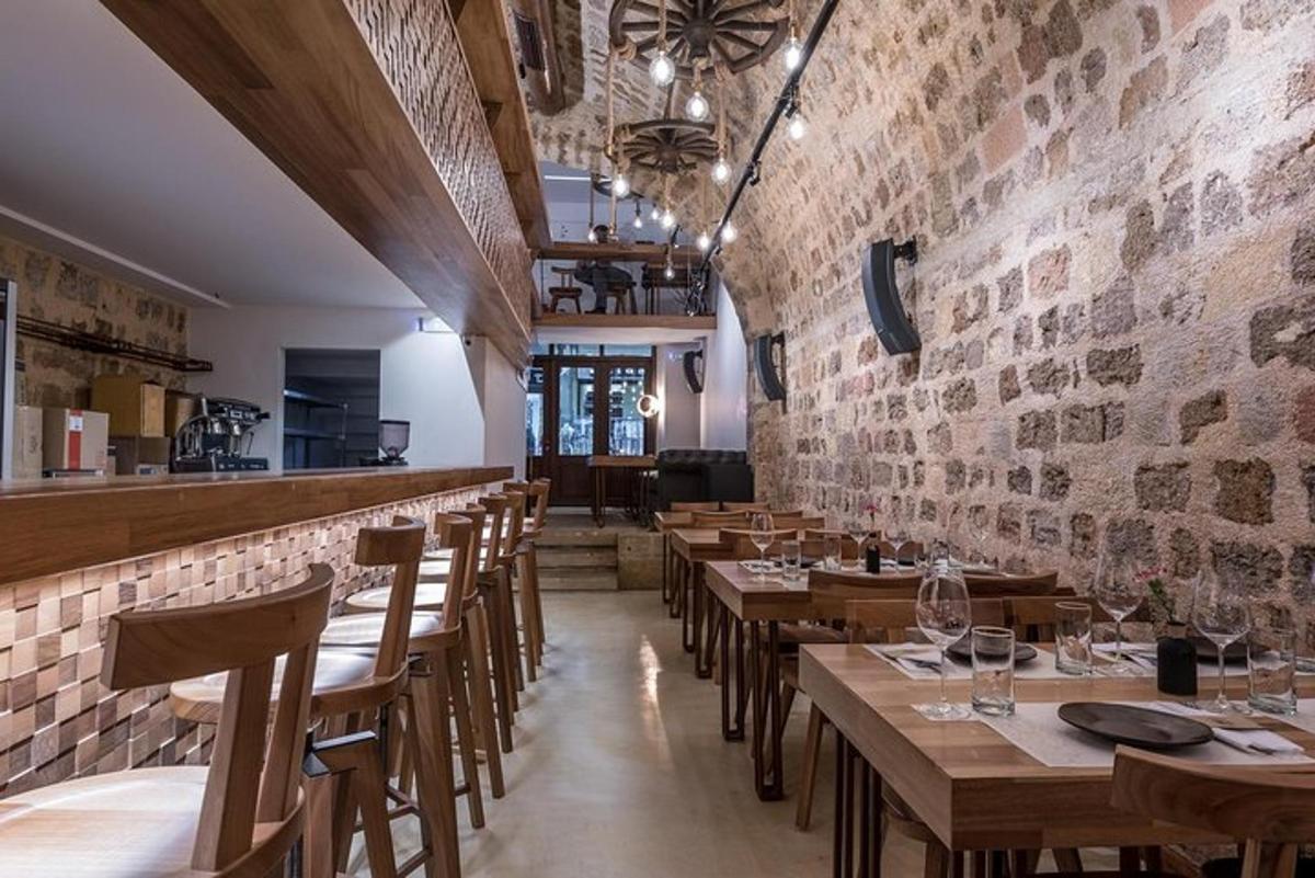 restoran puidust laudade ja toolidega ning telliskiviseinaga