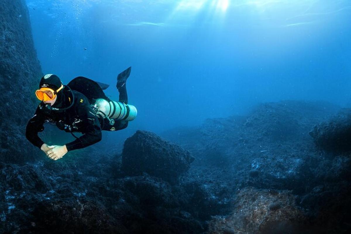 muž v potápěčském obleku plave v oceánu