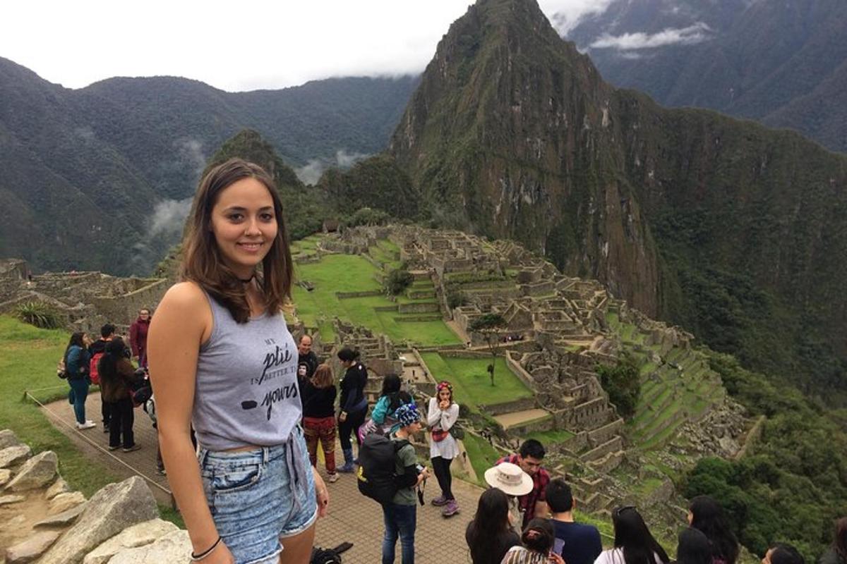 Una mujer parada frente a una vista de una montaña.