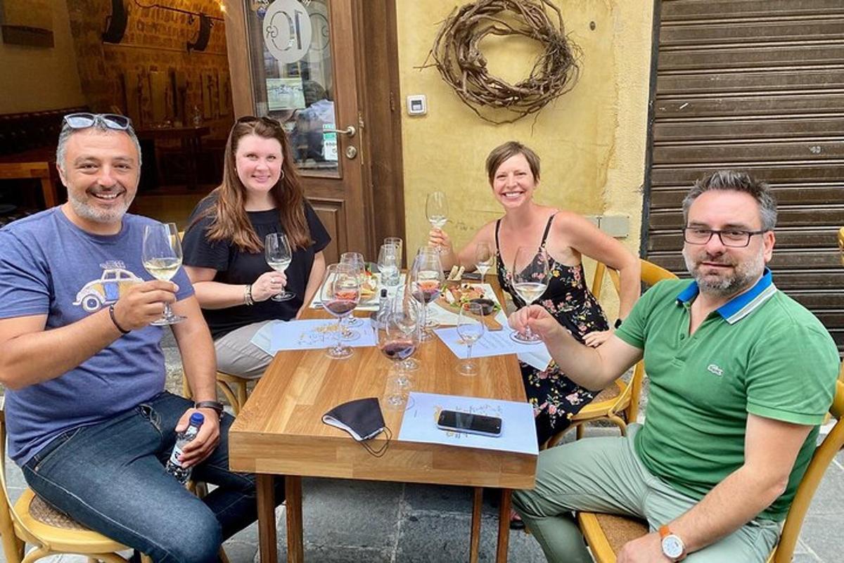 un gruppo di persone sedute attorno a un tavolo con bicchieri di vino
