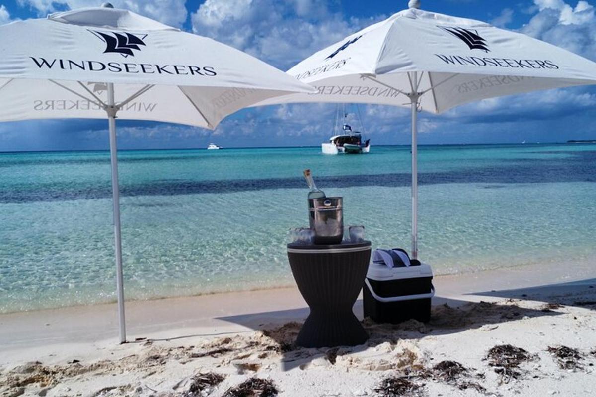 dva bela dežnika na plaži z oceanom