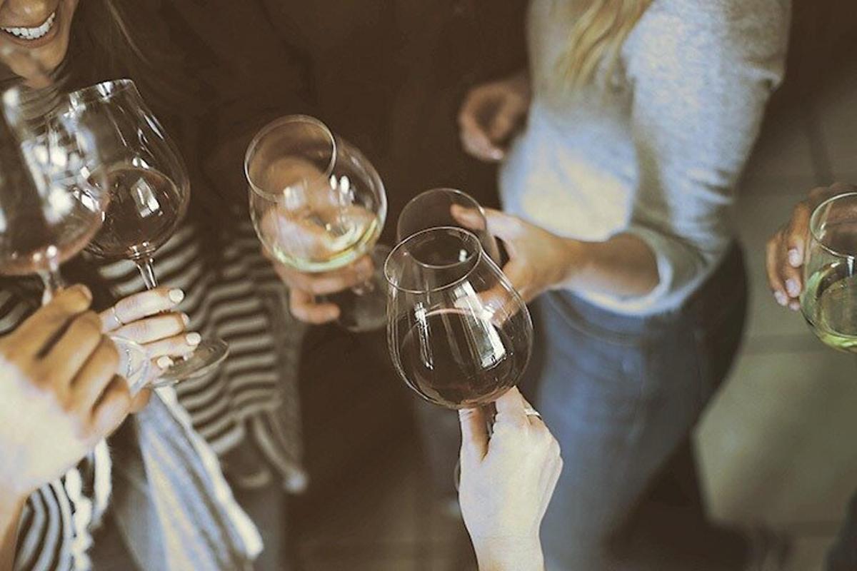 un gruppo di persone che sorreggono bicchieri di vino