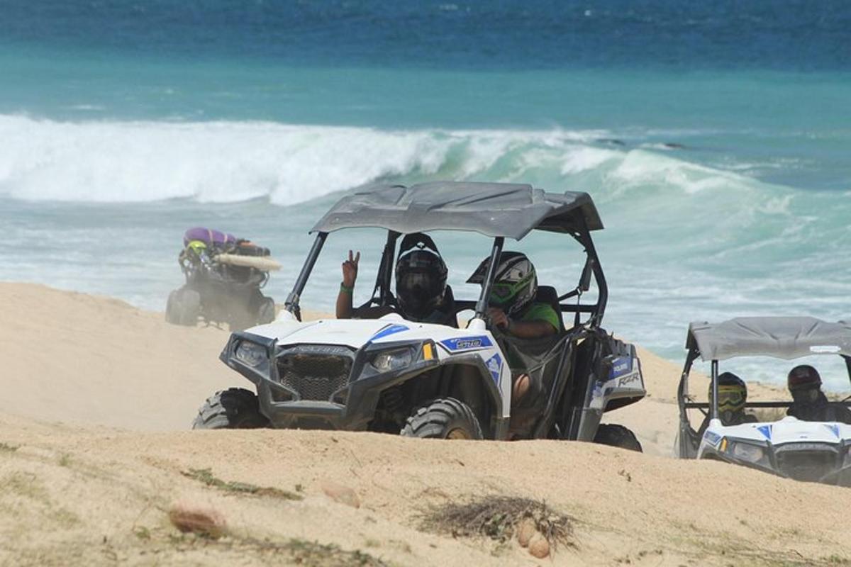 un gruppo di persone in sella a un quad sulla spiaggia