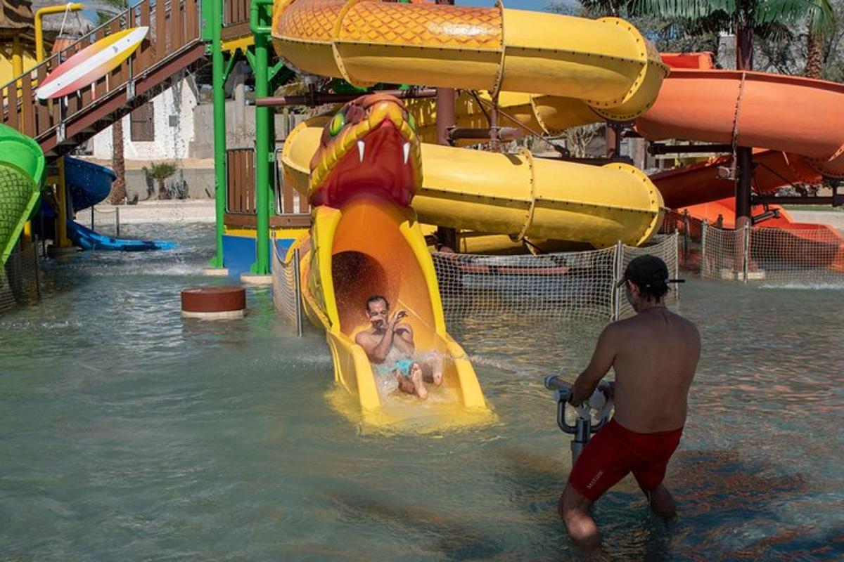 un paio di persone su uno scivolo d'acqua in un parco acquatico