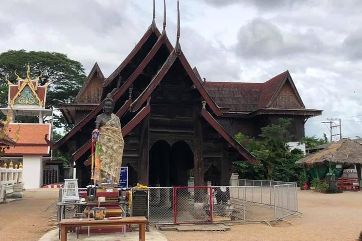 sebuah bangunan kayu yang besar dengan patung di hadapannya