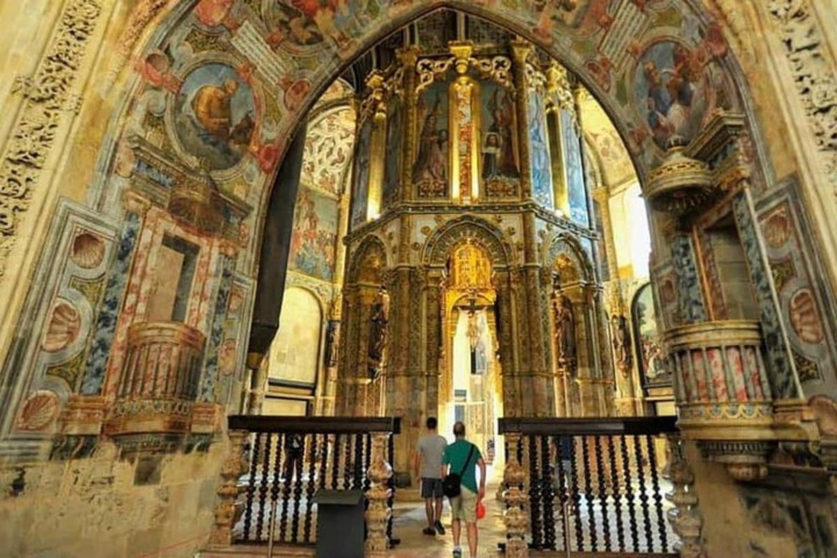 two people walking inside of a large building with paintings